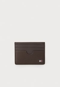 Porte-cartes din piele maro cu finisaj texturat, 4 sloturi pentru carduri și un accent cu logo în colțul din dreapta jos. Design minimalist.