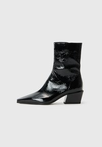 Bottines noires en cuir verni avec un bout pointu, une finition texturée et un talon bloc épais. Design épuré avec une surface lisse et brillante.