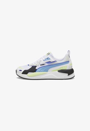 Biały sneaker z niebieskimi i czarnymi akcentami, jasnooliwkowymi dodatkami, sznurówkami i gumową podeszwą, logo Puma na boku i języku, widok z boku.