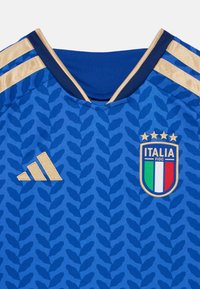 Blå fotbollsjersey med ett texturerat bladmönster, gyllene detaljer, v-ringad krage och Adidas-logga, med den italienska nationsskylten.
