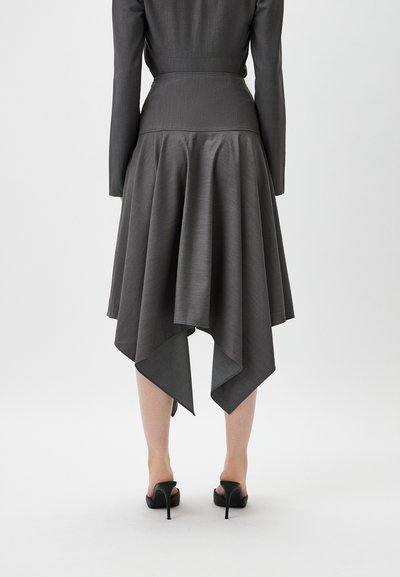Asymmetrical gray dress with a smooth texture; fitted bodice and flared skirt with a pointed hem. Paired with black high-heeled shoes.