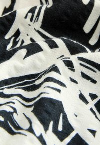 Schwarz-weißer Stoff mit organischen, wavy Linien. Weicher Textur mit leichtem Glanz, der natürlich fällt und sichtbare Fasern zeigt.