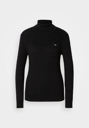 Mustmustarätik, millel on tekstuuriga vabrikud. Omaduseks on pikad varrukad ja kitsas siluett. Rinnal väike logo.