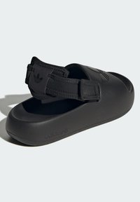 Black sandals made from textured rubber with a padded strap. Features a wide toe opening and embossed logo on the side.