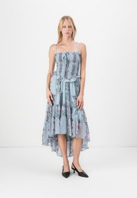 Abito lungo con corsetto aderente arricciato, spalline sottili, orlo con volants, motivo floreale blu su tessuto a righe e silhouette asimmetrica.