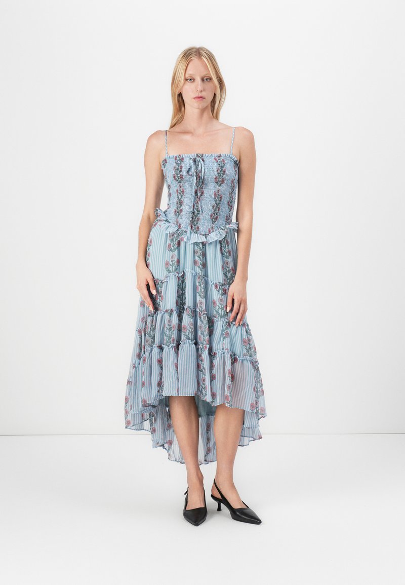 Abito lungo con corsetto aderente arricciato, spalline sottili, orlo con volants, motivo floreale blu su tessuto a righe e silhouette asimmetrica.
