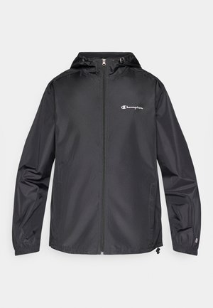 Schwarze, leichte Regenjacke mit Kapuze, Frontreißverschluss und elastischen Bündchen. Mit Champion-Logo auf der linken Brustseite und zwei Seitentaschen.