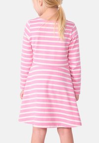 Rosa und weiß gestreiftes Kleid mit langen Ärmeln, tailliertem Oberteil und schwingendem Rock. Hergestellt aus weichem Stoff mit glatter Textur.