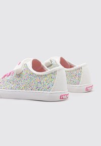 Zapatillas de lona blancas brillantes con cordones y acentos rosas, que cuentan con una capa superpuesta de brillantina multicolor brillante y suela de goma.