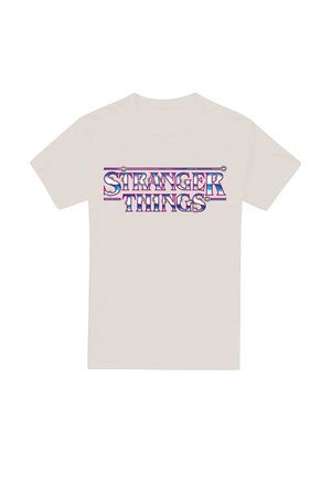 Beige t-shirt with shiny, metallic "STRANGER THINGS" text in blue, purple, and pink centered on the front.