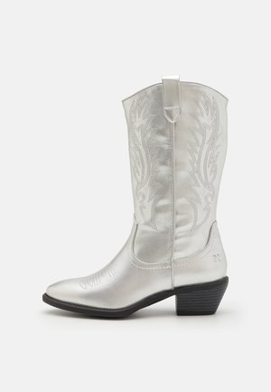 Botte de cowboy argentée avec bout pointu, couture décorative, talon bas empilé et une languette en haut. Fini en cuir métallique lisse.