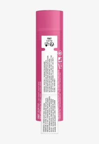 Prodotto per le labbra in un tubo cilindrico rosa lucido con etichetta bianca che dettaglia ingredienti e istruzioni per l'uso. Tappo sopra, testo stampato chiaramente visibile.