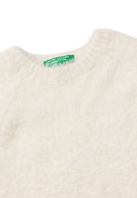 Miękki, biały, puszysty sweter z okrągłym dekoltem i zieloną metką United Colors of Benetton wewnątrz kołnierza.