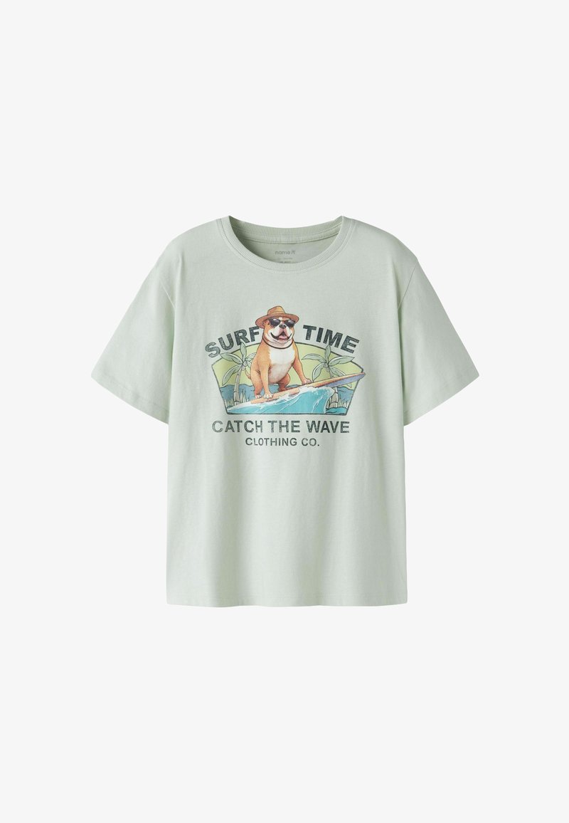 Φωτεινό πράσινο T-shirt με γραφικό ενός σκύλου που φοράει γυαλιά ηλίου και καπέλο, σερφάροντας, κείμενο «SURF TIME» και «CATCH THE WAVE CLOTHING CO.»