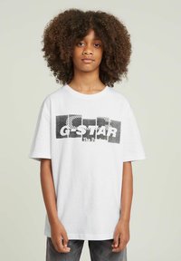 Hvid bomulds T-shirt med korte ærmer, der har et sort grafisk design, som inkluderer teksten "G-STAR" og stribede mønstre.