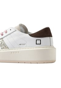 Sneaker in pelle bianca con dettaglio glitter argento, lacci rosa, tallone in camoscio marrone e suola spessa color crema. Caratterizzata da un branding minimalista.