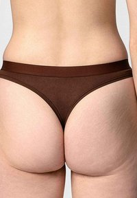 Donkergroene katoenen stringonderbroek met een gladde textuur en een brede elastieken tailleband, met een minimalistisch ontwerp en geen zichtbare print.