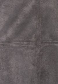 Tissu en suède gris avec une texture douce et un subtil éclat. Présente des panneaux cousus, créant un motif géométrique. Fini lisse et mat.