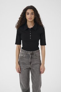 Černé polo tričko s krátkým rukávem, �žebrovanou strukturou, zapínáním na knoflíky a nenápadným logem. Kombinováno s šedými džíny s vysokým pasem.