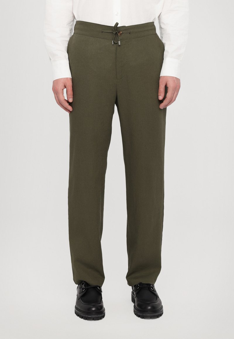 Olivenfargede linblandingsbukser med snor i livet og en enkelt knapp. Buksecutten er rett, og stoffet har en jevn tekstur.
