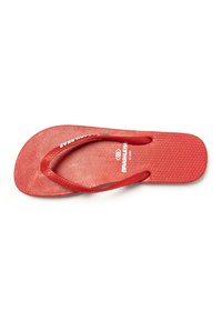 Chanclas rojas con suela texturizada y correas a juego. La plantilla presenta un patrón circular. Marca visible en la correa y la plantilla.