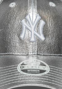 Boné de beisebol metálico prateado com o logótipo "NY" bordado em branco, faixa ajustável e etiqueta redonda com a inscrição "9FORTY WOMEN ADJUSTABLE."