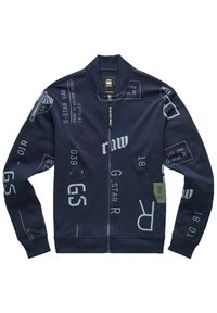 Sudadera con cremallera en color azul marino, hecha de algodón con una textura suave, que presenta impresiones gráficas en blanco y puños y cuello acanalados.