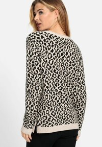 Leopardenmuster-Pullover in Creme und Schwarz, mit gerippten Bündchen und Saum. Bietet eine lockere Passform und seitliche Schlitze für zusätzlichen Komfort.