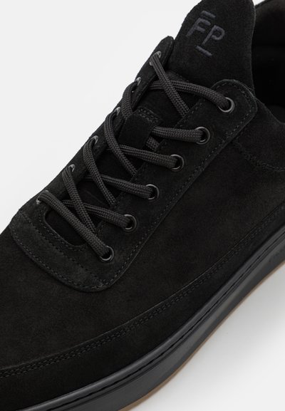 Sort ruskinds sneakers med flade sorte snører, rund tå og et minimalistisk design med en tykk sort gummisål og diskret branding.