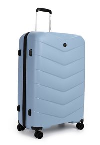 Tvrdý kufr světle modré barvy s chevronovým vzorem, černými akcenty, teleskopickou rukojetí a čtyřmi koly pro snadnou mobilitu.
