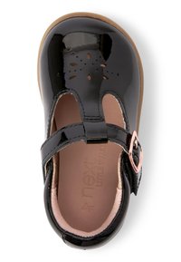 Czarne lakierowane buty typu Mary Jane z wyciętymi kwiatowymi detalami, różową wkładką i zapięciem na klamrę na beżowej gumowej podeszwie.