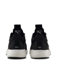 Zapatillas deportivas negras con parte superior de malla transpirable, talón texturizado y suela acolchada blanca. Presentan detalles en verde en el logo y la lengüeta.