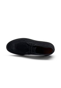Botín chukka de ante negro con punta redondeada, cierre de cordones en la parte delantera y detalles de costura sutiles. Forro interior suave y suela acolchada.
