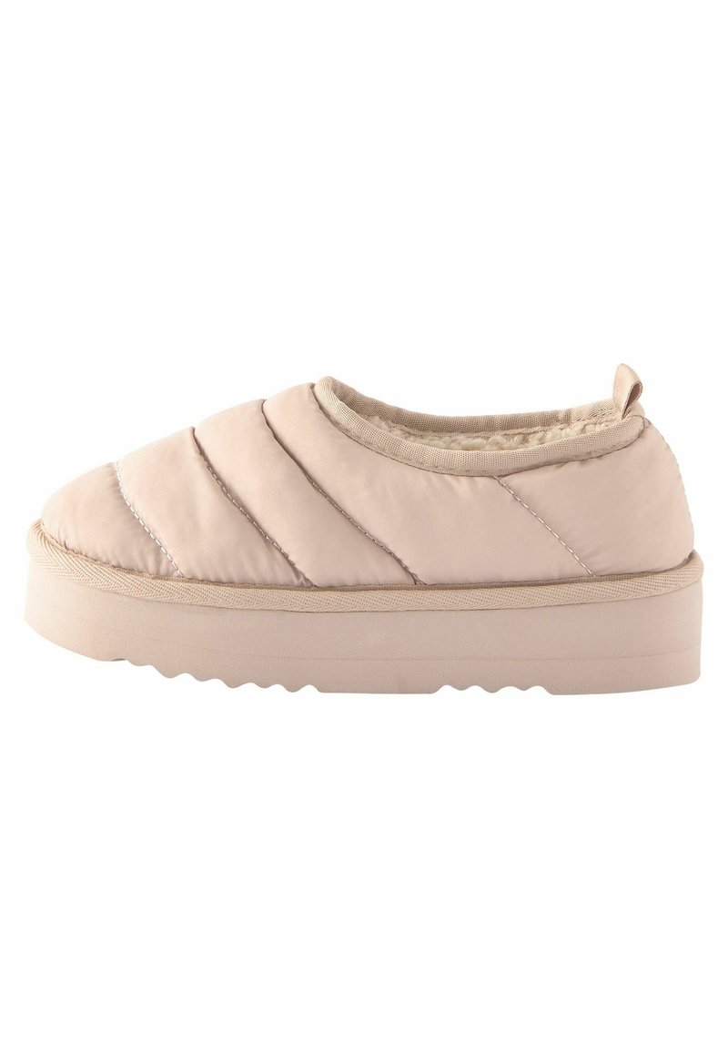 Scarpa slip-on imbottita in beige chiaro, caratterizzata da un design trapuntato, punta tonda e suola in gomma spessa con fondo testurizzato per una maggiore aderenza.