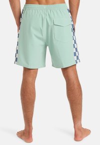 Mätové plavky s kockovaným vzorom v námorníckej modrej na stranách. Majú elastický pás a zadné vrecko.