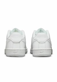 Vita Nike-sneakers med ovandel i slätt läder, vadderad krage och texturerad gummisula. Diskret Nike-logotyp på hälen.