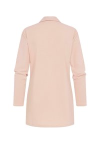 Langærmet, lyserød polo shirt med klassisk krave. Blødt stof, lige snit og længere rygslutning. Glat tekstur, ingen mønstre eller accentuer.