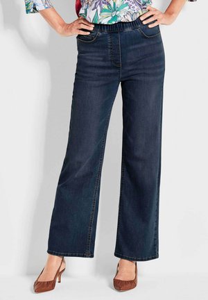Donkerblauwe wijde jeans met een rekbare tailleband, twee voorzakken en zichtbare stikseldetails. Het materiaal heeft een gladde denimtextuur.