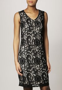 Černé krajkové šaty s výstřihem do V, bez rukávů, květinovými vzory a přiléhavým střihem, s jemnou texturou a zvlněným lemem.