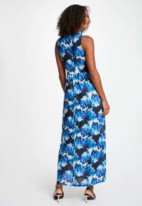 Robe maxi avec un motif floral bleu et noir, sans manches, en tissu léger, avec une taille cintrée et une jupe évasée.
