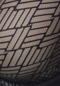 Fekete áttetsző szövet geometrikus mintázattal, összekapcsolódó vonalakkal, finom hálós textúrával és egyszínű fekete derékrésszel kiemelve.