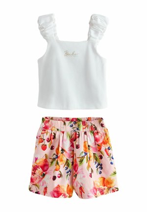 White sleeveless top with ruched straps and gold text paired with pink elastic-waist shorts featuring colorful fruit and floral print.