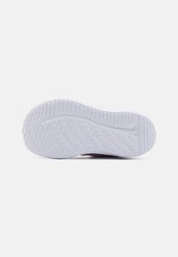 Semelle de chaussure de sport en caoutchouc blanc, texturée avec des motifs en diamant pour l'adhérence et la flexibilité. Fini lisse avec un détail de marque.
