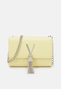 Gul läder crossbody-väska med silverkedjesnor. Har en "V"-logotyp och en fransdetalj. Slät yta, rektangulär design.