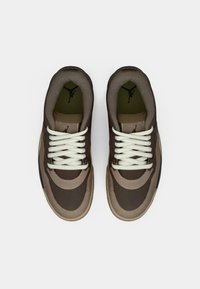 Par sneakers u smešnim i bež bojama s belim vezicama, prikazani odozgo na jednobojnoj beloj pozadini.