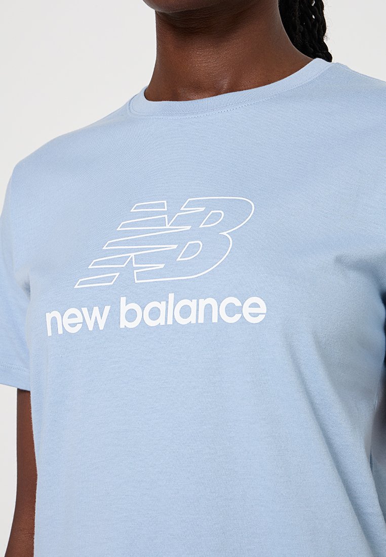 Helles blaues Baumwoll-T-Shirt mit einem weißen "New Balance"-Logo. Das Design ist einfach mit einem Rundhalsausschnitt und kurzen Ärmeln.