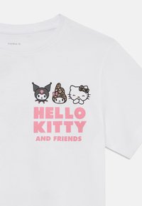 T-shirt en coton blanc avec trois personnages de dessin animé et le texte "HELLO KITTY ET SES AMIS" en rose. Design simple, manches courtes.