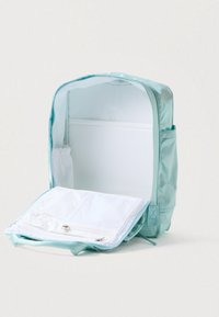 Svijetloplavi materijalni ruksak s glatkom teksturom, koji ima otvoreni dizajn i bijele mrežaste pregrade za organizaciju.