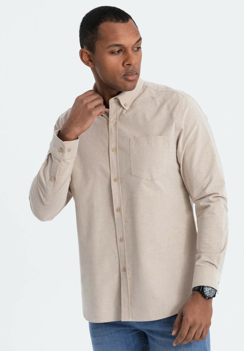 Beige overhemd met lange mouwen, een button-down kraag, een enkele borstzak en contrasterende knopen. Iets gestructureerde stof, getailleerde pasvorm.