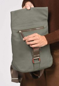 Sac messager vert en matériau lisse, doté d'une poche avant zippée, d'une sangle réglable et d'accents de quincaillerie contrastants.